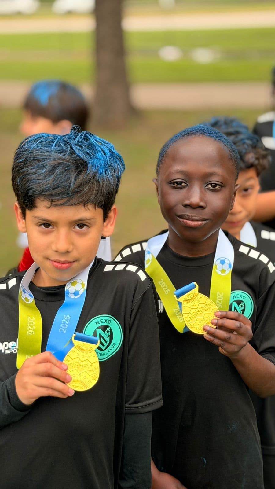 Two NEXO players show their gold championship medals